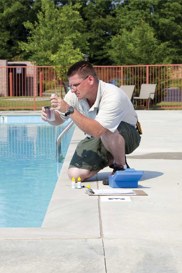 Man testing pH in pool