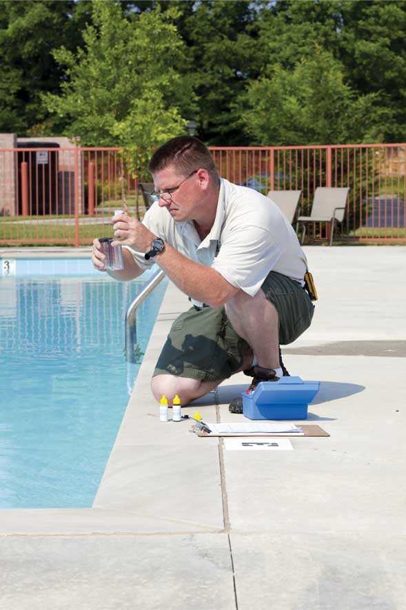 pH_Man Man testing pH in pool